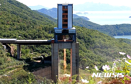 【서울=뉴시스】조선중앙TV는 김정은 노동당 위원장 겸 국무위원장이 평북도 동창리 서해 위성발사장에서 정지위성 운반로켓용 대출력 엔진 지상분출시험을 지도했다고 20일 보도했다.&nbsp; 이날 엔진 지상분출시험 현장에서는 리병철, 김정식 등 조선노동당 중앙위원회 책임일군들과 국가우주개발국 일군들이 김 위원장을 맞았다.&nbsp; 사진은 미사일 발사대 모양 장치에 설치된 엔진의 분출 시험 장면. 2016.09.20. (사진=조선중앙TV 캡쳐)&nbsp; photo@newsis.com