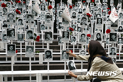 【뉴욕=AP/뉴시스】미국 뉴욕 유엔본부 앞에서 2016년 9월 20일 한 여성이 이란에서 처형된 약 3만명의 사진을 일일이 붙이는 시위에 참가하고 있다. 이 시위를 조직한 이란미국커뮤니티기구는 이란 정부의 인권 탄압을 비판하고 민주적 변화를 촉구했다. 2025.06.19. 