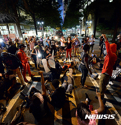 【샬럿=AP/뉴시스】 팻 맥크로리 미국 노스캐롤라이나 주지사는 21일(현지시간) 성명을 내고 경찰의 흑인 총격 사살에 항의하는 폭력 시위가 이틀 째 이어지고 있는 샬럿에 비상 사태를 선포했다. 또 폭력 사태 진압을 위해 주 방위군을 이 곳에 파견한다고 밝혔다. 사진은 거리에서 시위가 벌어지고 있는 모습.2016.09.22  