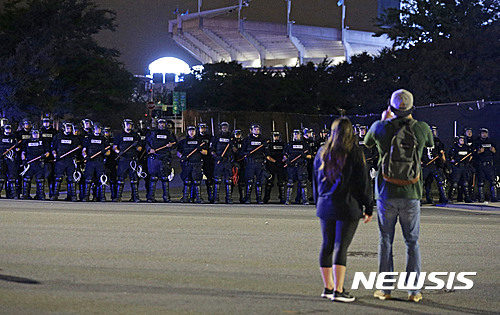 【샬럿=AP/뉴시스】미국 노스캐롤라이나주 샬럿에서 22일(현지시간) 경찰의 흑인 총격 사살에 항의하는 시위가 사흘째 계속되고 있다. 사진은 시민들이 거리에 배치된 경찰 병력을 지켜보는 모습. 2016.9.23. 