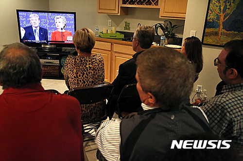 【센테니얼=AP/뉴시스】미국 콜로라도주 센테니얼에서 26일(현지시간) 공화당 소속의 스펜서 스왐 전 하원의원과 민주당 소속의 조 미클로시 전 하원의원 및 친지들이 한 자리에 모여 첫 대선주자 TV 토론 방송을 지켜보고 있다. 2016.09.27 