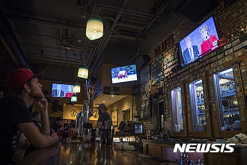 【신시내티=AP/뉴시스】미국 오하이오주 신시내티의 한 술집에서 26일 (현지시간) 손님들이 대선 주자 첫 TV토론을 지켜보고 있다. 2016.09.27 