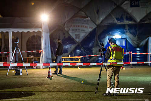 Police officers investigate the scene of a shooting in front of an air-inflated structure which is a shelter for refugees in Berlin, Wednesday morning, Sept. 28, 2016. A 29-years-old man has been killed by police after a knife attack. (Gregor Fischer/dpa via AP)