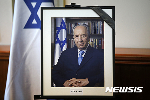 【예루살렘=AP/뉴시스】베냐민 네타냐후 이스라엘 총리와 각료진이 28일(현지시간) 예루살렘에서 긴급회의를 열고 있는 회의장 한 쪽에 이날 별세한 시몬 페레스 전 대통령의 사진이 놓여있다. 2016.09.28 