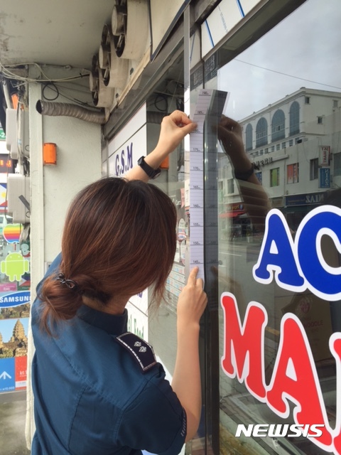 【대구=뉴시스】박준 기자 = 대구 서부경찰서는 4일 대구 서구 북부정류장 일대 외국인 출입업소, 편의점, 은행, 노래방을 대상으로 범죄 신고 방법과 홍보 문구가 프린트된 신장측정표를 배포했다. 신장측정표는 폐쇄회로(CC)TV에 찍힌 범인의 영상으로 인상착의를 특정하는 데 중요한 수사단서로 활용 가능하고 범인들에게 자신의 키가 노출되는 심리적 부담감을 줌으로써 범죄율이 시행 전보다 감소하는 효과를 줄 수 있다. 2016.10.04.(사진=대구 서부서 제공) photo@newsis.com