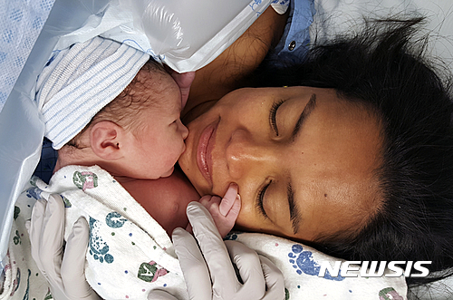 【AP/뉴시스】 지난 9월 4일 태어난 라이언 그래슬리의 둘째 아기와 아내 린다. 유타주 프로보의 유타 밸리종합병원은 약 40달러의 요금을 "아기에 대한 접촉"이란 항목으로 부과해 인터넷에서 큰 반향을 불러일으켰다. 2016.10.06