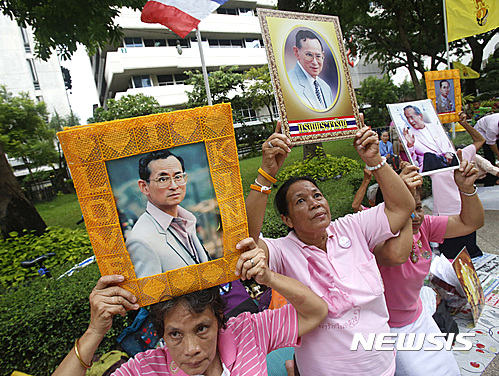 【방콕=AP/뉴시스】태국 여성들이 11일 푸미폰 아둔야뎃 국왕이 입원하고 있는 방콕의 병원 앞에서 국왕 사진을 들고 건강을 기원하고 있다.&nbsp; 2016.10.11 