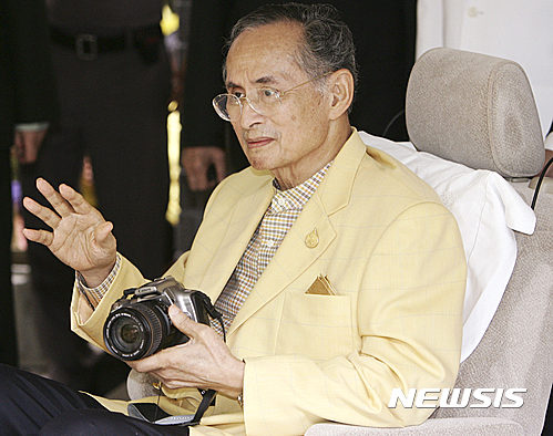 【방콕=AP/뉴시스】푸미폰 아둔야뎃 태국 국왕이 13일 88세로 세상을 떠났다. 사진은 지난 2006년 8월 4일 방콕에서 병원에 입원했다 퇴원하며 손에 카메라를 들고 있는 모습. 2016.10.13&nbsp; 