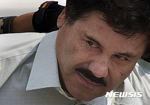 【멕시코시티=AP/뉴시스】2015년 2월22일 멕시코 수도 멕시코시티의 해군 격납고에서 수갑을 찬 마약왕 호아킨 '엘 차포' 구스만이 해군과 해병대원에 이끌려 헬기에 올라타고 있다. 멕시코 당국이 멕시코시티 인근에서 마약과 관련, 8명을 살해한 혐의로 '엘 차피토'라는 별명의 14살 소년을 체포했다. '작은 차포'(Little Chapo)라는 의미의 그의 별명은 투옥된 마약왕 호아킨 '엘 차포' 구스만에서 따온 것이다. 2023.3.17.