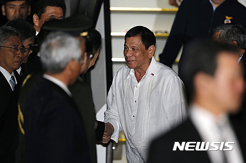 【도쿄=AP/뉴시스】로드리고 두테르테 필리핀 대통령이 25일 일본 도쿄 하네다 국제공항에 도착해 마중 나온 관계자들과 악수하고 있다. 2016.10.25&nbsp; 