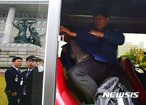 【서울=뉴시스】조성봉 기자 = 26일 오전 서울 여의도 국회 본청 계단에서 ‘박근혜 탄핵 대학생 운동본부’ 학생들이 ‘국회는 즉각 박근혜를 탄핵하라’ 는 플래카드와 성명서를 뿌리며 기습시위를 벌이자 경찰이 연행해 호송차량에 태우고 있다. 2016.10.26. suncho21@newsis.com
