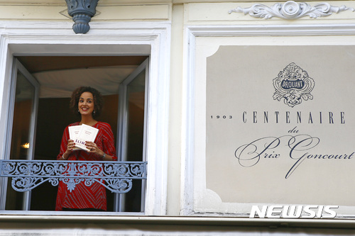 【파리=AP/뉴시스】프랑스 여성 소설가 레일라 슬라마니가 3일(현지시간) 파리에 있는 한 식당에서 공쿠르상 수상자로 선정된 후 자신의 소설 '샹송 두스'를 들고 미소를 짓고 있다. 공쿠르상은 프랑스에서 가장 권위 있는 문학상이다. 2016.11.04