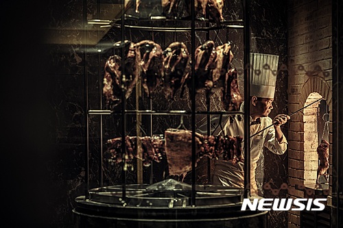 【서울=뉴시스】포시즌스 호텔 서울 중식당 ‘유유안’에서 사이먼 우 총괄 셰프가 페킹 덕 요리를 하고 있다.