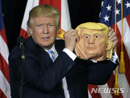 【새러소타=AP/뉴시스】미국이 500억 달러(약 54조원) 규모의 중국산 첨단기술 제품들에 대해 25%의 고율 관세를 부과하기로 한 결정을 당초 계획대로 실행한데 대해 30일 중국 외교부가 미국 측이 변검(變瞼·태도를 바꾸다)할 때마다 그 국가 신용과 명예가 훼손된다고 강력히 비난했다. 지난 2016년 11월7일 공화당 대선후보던 트럼프가 미 플로리다주 새러소타 유세에서 자신의 얼굴을 본따서 만든 가면을 들고 있다. 2018.05.30 