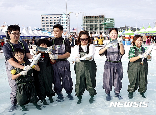 '최남단방어축제'에서 참가자들이 맨손으로 방어를 잡은 뒤 들어보이고 있다. <뉴시스 DB>
