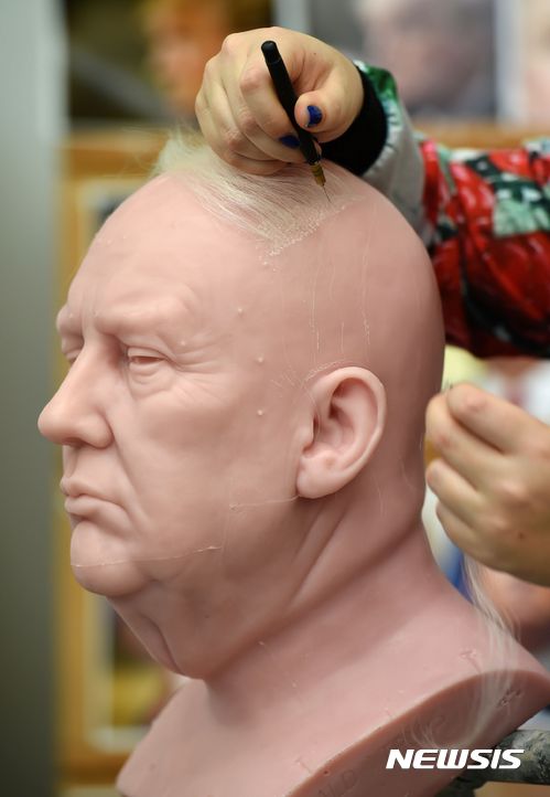 【런던=AP/뉴시스】도널드 트럼프(70) 미국 제45대 대통령 당선인의 미완 밀랍인형. 9일 영국 런던 마담투소 스튜디오직원이 머리에 야크 털을 심고 있다. 내년 1월 일반에 선보일 예정이다. 트럼프는 첫 부인인 체코 태생 이바나(67)와 사이에 2남(39·32) 1녀(35), 둘째부인 말라 메이플스(53) 사이에 1녀(23), 현 부인인 슬로베니아 출신 모델 멜라니아(46) 사이에 1남(10)을 뒀다. 트럼프의 아버지는 독일계, 어머니는 스코틀랜드계다. 188㎝ 90㎏에 300㎜ 신발을 싣는 거구.&nbsp;&nbsp;&nbsp; reap@newsis.com&nbsp; 