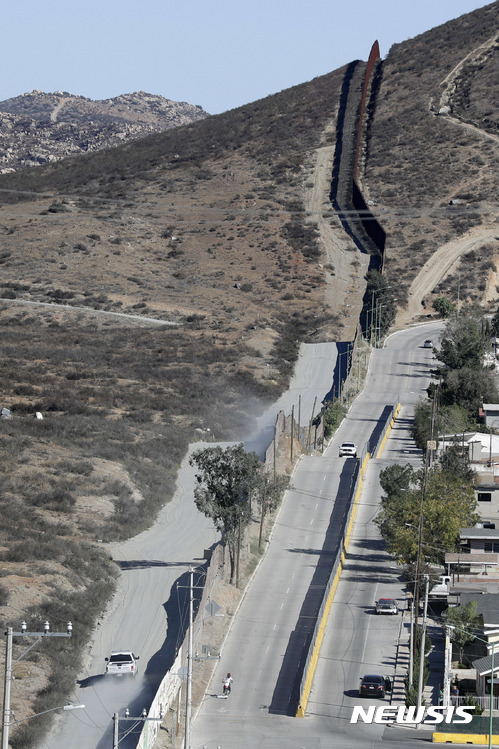 【테카테=AP/뉴시스】미국 캘리포니아주 테카테(왼쪽)와 멕시코 테카테 사이에 9일 (현지시간) 국경장벽이 놓여있다. 트럼프 대통령 당선인은 미국 국경장벽의 확대 건설과 멕시코 불법이민자 추방을 공약으로 내걸었다. 2016.11.10 