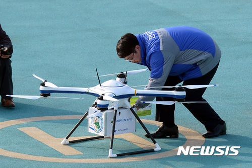 【영월=뉴시스】이영환 기자 = 지난해 11월 강원도 영월군 드론 시험사업공역(영월영업소~농업기술센터)에서 국토교통부 주최로 열린 드론시범사업 공개시연회에서 유콘시스템과 현대로지스틱스가 협업한 배송용 드론 RemoCopter-020C가 배송한 물품을 관계자가 꺼내고 있다. 2016.11.16. 20hwan@newsis.com