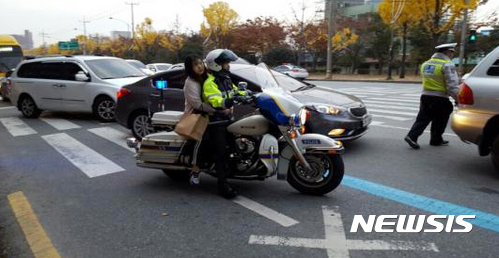 【광주=뉴시스】신대희 기자 = 2017학년도 대학수학능력시험일인 17일 오전 7시55분께 광주 동구 조선대 네거리에서 수험생 고모(18·여)양이 "출근길 차가 막혀 지각할 것 같다"고 인근에 있던 김근상 경위에게 도움을 요청, 경찰 오토바이를 타고 시험장인 조대여고로 이동하고 있다. 2016.11.17. (사진 = 광주경찰청 제공)&nbsp; photo@newsis.com 