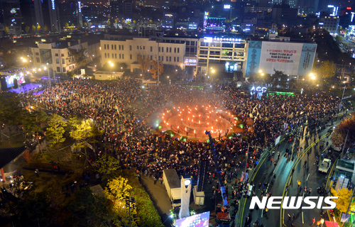 【광주=뉴시스】류형근 기자 = 19일 오후 광주 동구 5·18민주광장(옛 전남도청)에서 박근혜퇴진 광주시민운동본부 주관 '대통령 퇴진 촛불집회'가 열린 가운데 한 시민단체가 광장 분수대에서 횃불을 들고 있다. 이날 집회에는 오후 8시기준 주최측 추산 10만명, 경찰추산 1만9000명이 참석했다. 2016.11.19.&nbsp; hgryu77@newsis.com