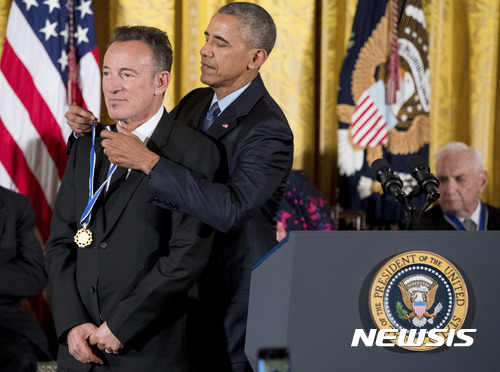 【워싱턴= AP/뉴시스】버락 오바마 미국대통령이 22일(현지시간) 백악관 이스트 룸에서 싱어송라이터인 브루스 스프링스턴에게 대통령 자유메달을 걸어주고 있다. 이 날 시상식에는 올해의 대통령 자유메달 수상자로 선정된 21명 중 가수, 과학자, 자선사업가 등 다수가 참석했다. 2016.11.23 