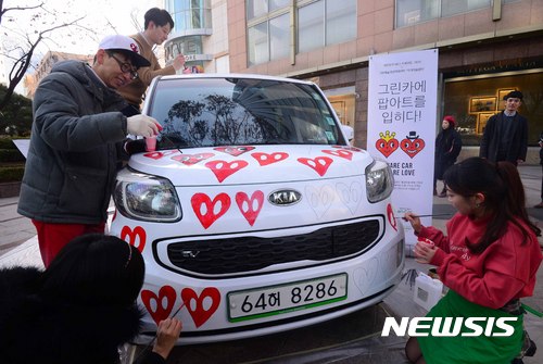 【서울=뉴시스】전신 기자 = 28일 서울 소공동 롯데호텔 앞에서 열린 카셰어링 페인팅 퍼포먼스에서 팝아티스트 찰스장이 시민들과 함께 전기차 레이에 그림을 그리고 있다. 이번 행사에서 제작된 레이 스페셜 에디션은 그린카의 셰어링카로 작가 미술장터의 활성화를 위해 운영될 예정이다. 2016.11.28 photo1006@newsis.com