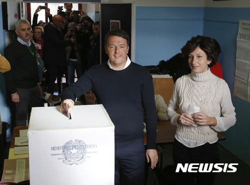 【폰타시에비=AP/뉴시스】마테오 렌치 이탈리아 총리가 4일(현지시간) 폰타시에베 투표소에서 부인 아그네세와 함께 개헌안 국민투표에 참여해 투표함에 표를 넣고 있다. 2016.12.05 