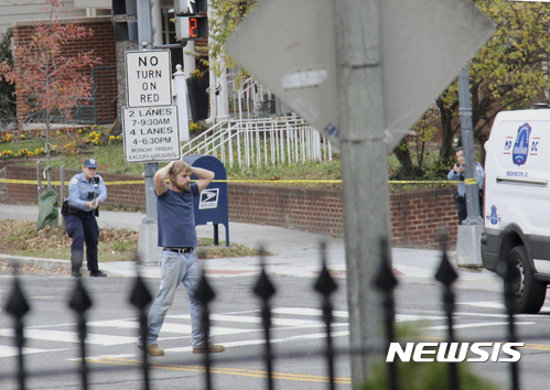 【 워싱턴=AP/뉴시스】미국 수도 워싱턴에서 4일(현지시간) 에드거 매디슨(오른쪽)이란 이름의 남성이 총을 들고 피자가게 코멧 핑퐁을 습격한 후 경찰에 투항하고 있다. 매디슨은 힐러리 클린턴 민주당 대선후보가 문제의 피자가게 비밀방에서 아동 성매매 조직을 굴리고 있다는 '가짜 기사'를 본 후 직접 진상을 밝히기 위해 습격을 감행했다고 주장했다. 2016.12.08 