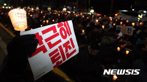 [광주=뉴시스]신대희 기자 = 박근혜퇴진 광주시민운동본부가 7일 오후 광주 북구 중흥동 새누리당 광주시당사 앞에서 '박근혜 즉각퇴진·부역정당 새누리당 해체 광주 시국대회'를 열고 있다. 시국대회 참가자들이 손피켓과 촛불을 들고 있다. 2016.12.07. sdhdream@newsis.com