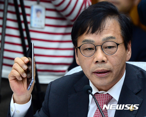 【서울=뉴시스】박주성 기자 = 여당 간사인 새누리당 이완영 의원이 14일 오전 서울 여의도 국회에서 열린 최순실 국정농단 의혹 진상규명을 위한 국정조사 특위 3차 청문회에서 "어제는 야당 간사가 언론에 간사간 협의 내용 공개해서 언론 지탄 받았다"며 "제 핸폰 뜨거워서 사용 못한다"고 말하며 핸드폰을 들어보이고 있다. 이날 이완영 의원은 비난 여론에 떠밀려 국회 최순실 국정조사 특위 간사직을 사퇴했다. 2016.12.14. park7691@newsis.com
