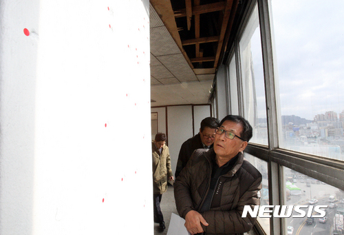 【광주=뉴시스】신대희 기자 = 정수만(70) 전 5·18 민주유공자유족회장이 14일 오후 광주 동구 금남로 전일빌딩 10층 옛 전일방송 영상 데이터베이스(DB) 사업부 사무실을 찾아 기둥에 남겨진 총탄 흔적을 살피고 있다. 2016.12.14.&nbsp; sdhdream@newsis.com