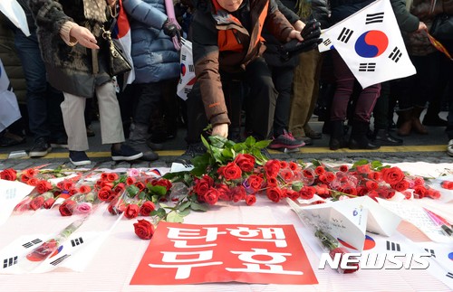 【서울=뉴시스】홍효식 기자 = 박근혜를 사랑하는 모임(박사모)등 보수단체 회원들이 17일 오후 서울 종로구 안국역 인근에서 집회를 열고 청와대로 행진한 뒤 장미꽃을 놓고 있다. 2016.12.17. yesphoto@newsis.com
