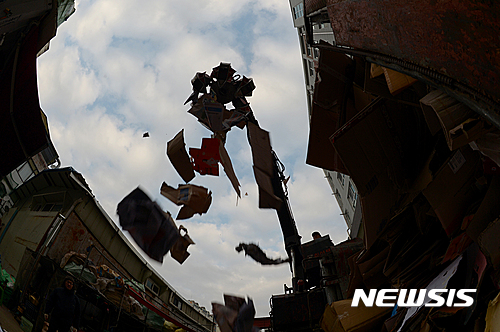 【안양=뉴시스】조수정 기자 = 14일 경기 안양시 만안구 안양동 창진고물상에서 본지 박성환 기자가 폐지 수거 체험을 했다. 창진고물상 사장이 집게발로 폐지를 옮기고 있다. 2016.12.19.&nbsp; chocrystal@newsis.com