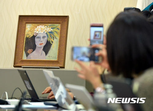 【서울=뉴시스】이영환 기자 = 19일 오후 서울 서초구 서울중앙지방검찰청 소회의실에서 열린 고 천경자 화백 '미인도' 위작 논란 사건 수사결과 브리핑에서 '미인도'가 공개되고 있다. 검찰은 25년간 위작 논란이 일었던 천 화백의 미인도가 진품이라는 결론을 내렸다. 2016.12.19.&nbsp; 20hwan@newsis.com