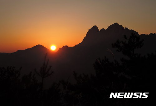 【서울=뉴시스】성탄절인 25일 새벽 노고산에서 바라본 북한산 영봉(왼쪽)과 인수봉 사이로 붉은 해가 치솟아 온누리를 비추고 있다. 2016.12.25. (사진=이형기 알피니스트 제공)&nbsp; hipth@newsis.com&nbsp;&nbsp;&nbsp;&nbsp;&nbsp;&nbsp;&nbsp; 