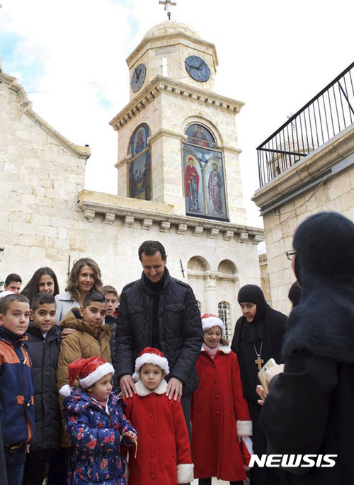 【 시리아대통령실·AP/뉴시스】시리아 내전이 6년동안 이어지고 있는 가운데 바샤르 알 아사드 대통령과 부인 아스마 여사는 25일(현지시간) 수도 다마스쿠스 북쪽 세드나야에 있는 수녀원을 찾아 고아 어린이들과 크리스마스를 축하하고 있다. 사진은 시리아대통령실에서 페이스북을 통해 제공한 것이다. 2016.12.25&nbsp; 
