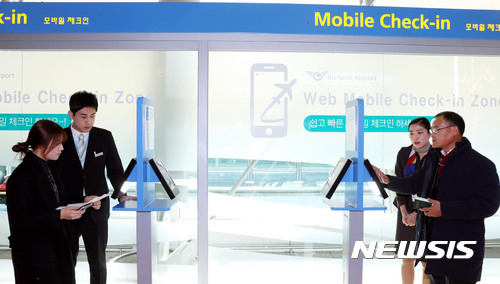 【인천공항=뉴시스】홍찬선 기자 = 28일 오전 인천공항 출국장 웹 모바일 존에서 여객들이 태블릿 PC를 이용해 모바일 체크인을 하고 있다. 2016.12.28.(사진=인천공항공사 제공)&nbsp;&nbsp; photo@newsis.com