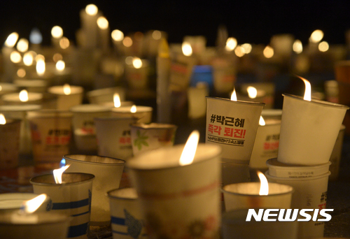 【서울=뉴시스】조수정 기자 = 2016년 병신년(丙申年) 마지막날인 31일 밤서울 광화문광장에서 열린 박근혜 대통령 퇴진 촉구 제10차 주말 촛불집회에서 시민들이 촛불을 바닥에 놓고 있다. 2017.01.01.  chocrystal@newsis.com