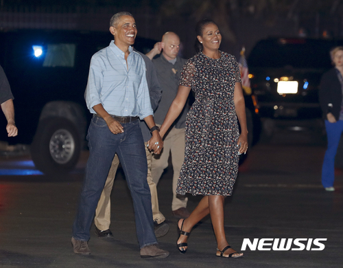 【호놀룰루=AP/뉴시스】버락 오바마 미국 대통령과 퍼스트레이디 미셸 여사가 1일(현지시간) 하와이 호놀룰루 진주만-히캄 기지에서 연말 휴가를 마치고 워싱턴 DC로 복귀하기 위해 다정히 손을 잡고 전용기 쪽으로 걸어가고 있다. 2017.01.02&nbsp; 