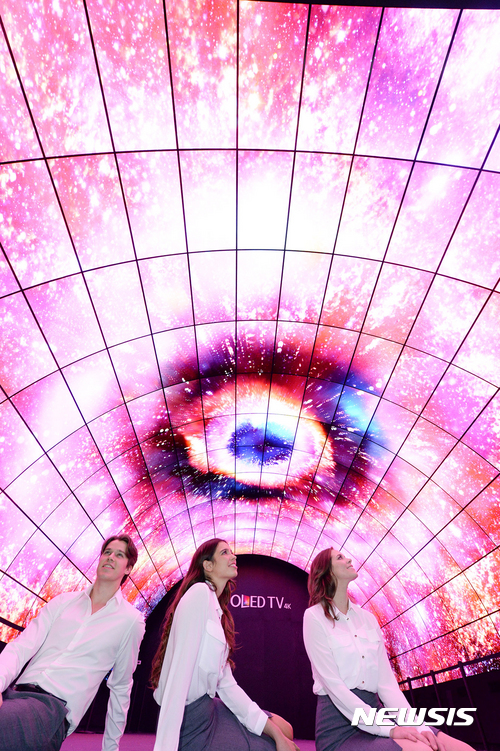 【서울=뉴시스】LG전자가 5일부터 8일까지(현지시간) 미국 라스베이거스에서 열리는 'CES 2017'에서 올레드 사이니지 216대를 이용해 너비 7.4m, 높이 5m, 길이 15m 규모의 올레드 터널을 구성하고, 오로라의 신비로운 분위기를 연출했다. 2017.01.04. (사진=LG전자 제공)&nbsp; photo@newsis.com