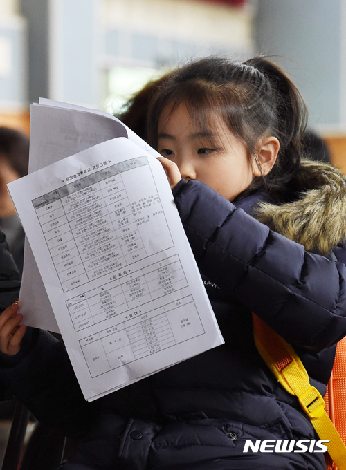 【대전=뉴시스】함형서 기자 = 5일 오전 대전 유성구 상지초등학교 예비소집일에 학교를 찾은 아이가 입학안내문을 보고 있다. 2017.01.05. foodwork23@newsis.com