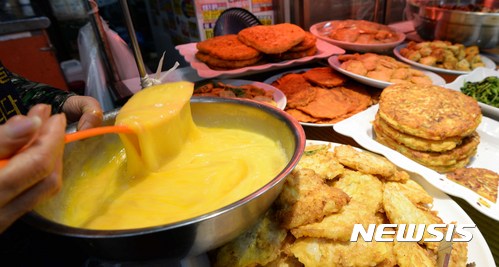 【서울=뉴시스】고범준 기자 = 조류인플루엔자(AI)가 발생해 산란계의 대대적인 살처분으로 계란 공급량이 줄고 가격이 폭등해 계란을 주재료로 하는 전(煎)집들이 직격탄을 맞고 있다.&nbsp; 설상가상으로 지난해 남미 홍수로 식용유 원료인 콩 수입량이 줄어들며 식용류값이 오르며 생활물가가 줄줄이 인상되어 서민가게에 주름살이 지고 있다. 사진은 5일 오후 서울 종로구 통인시장에서 한 상인이 요리를 만들기 위해 계란을 풀고 있다. 2017.01.05.&nbsp; bjko@newsis.com