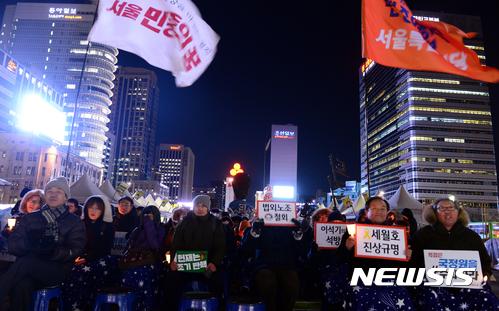 【서울=뉴시스】조성봉 기자 = 10일 오후 서울 종로구 광화문 광장에서 열린 '청와대 공작정치, 종북몰이 청산과 민주주의 회복을 위한 촛불집회'에서 시민들이 '헌재는 조기탄핵' 이라고 적힌 손피켓과 촛불을 들고 있다. 2017.01.10. suncho21@newsis.com