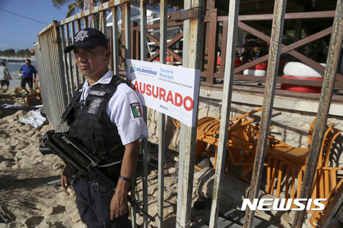 【칸쿤=AP/뉴시스】멕시코 동부 휴양 도시 칸쿤에 위치한 플라야 델 카르멘 리조트의 블루 패럿 나이트클럽에서 16일(현지시간) 오전 2시 30분께 총격전이 발생해 최소 5명이 숨지고, 15명이 다쳤다. 사건 발생 후 한 경찰이 사건 현장인 블루 패럿 나이트클럽 앞을 지키고 있다. 2017.01.17.