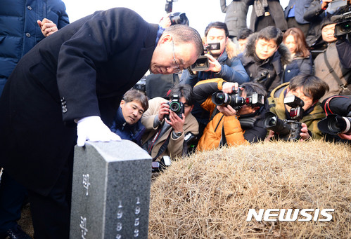 【광주=뉴시스】추상철 기자 = 반기문 전 유엔 사무총장이 18일 오전 광주 북구 국립 5.18 민주묘지에서 묘비를 어루만지고 있다. 2017.01.18.   scchoo@newsis.com