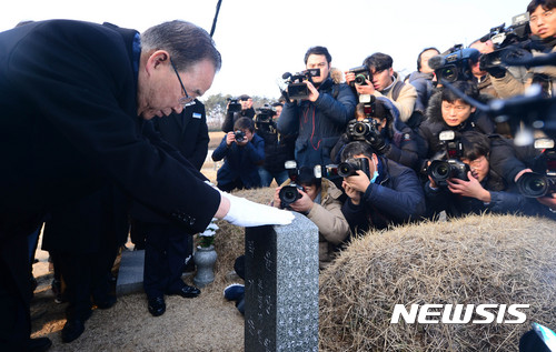 【광주=뉴시스】추상철 기자 = 반기문 전 유엔 사무총장이 18일 오전 국립 5.18민주 묘지에서 묘비를 어루만지고 있다. 2017.01.18.   scchoo@newsis.com