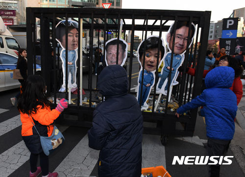 【울산=뉴시스】배병수 기자 = 21일 오후 울산롯데백화점 광장에서 영하의 날씨속에서 '박근혜 퇴진 울산시국촛불대회'가 열리고 있다. 사진은 어린이들이 철창에 갇힌 조형물을 향해 모래주머니를 던지고 있다. 2017.01.21.  bbs@newsis.com 