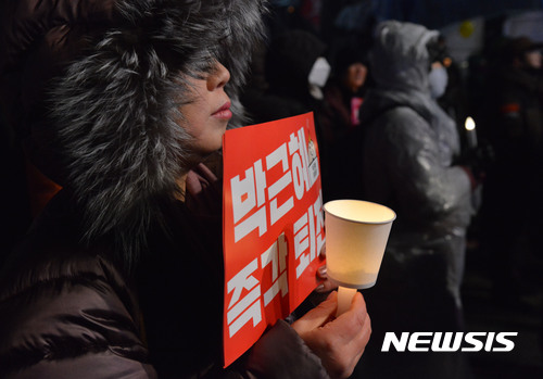 【서울=뉴시스】김선웅 기자 = 강추위가 몰아친 21일 오후 서울 종로구 광화문광장에서 열린 '박근혜 대통령 즉각 퇴진과 조기 탄핵, 재벌 총수 구속을 촉구하는 13차 주말 촛불집회'에서 시민들이 촛불을 들고 대통령 퇴진을 촉구하고 있다. 2017.01.21.  mangusta@newsis.com