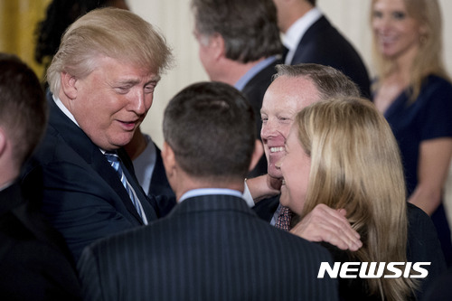 【AP/뉴시스】 = 도널드 트럼프 대통령이 22일(현지시간) 백악관 이스트룸에서 열린 션 스파이서 백악관 대변인( 오른쪽에서 두번 째) 의 취임식에서 그를 축하해주고 있다.     
