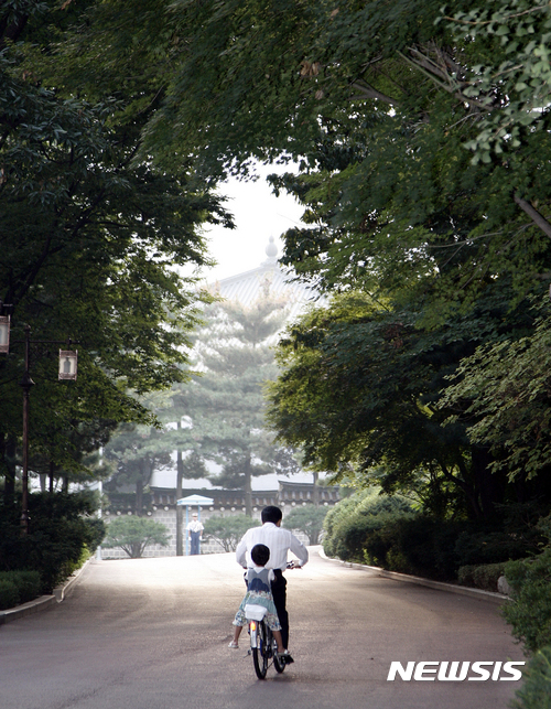 【서울=뉴시스】고 노무현 대통령 전속 사진사 장철영 씨가 촬영한 2007년 9월 13일 청와대에서 손녀를 뒷자리에 태우고 자전거를 타는 대통령의 모습. 대통령은 손녀가 아프지 않도록 뒷자리에 손수건을 깔았다. (사진=장철영 제공) 2017.01.31. chocrystal@newsis.com